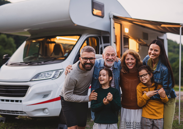Multi-generational family posing for photo on evening caravan holiday