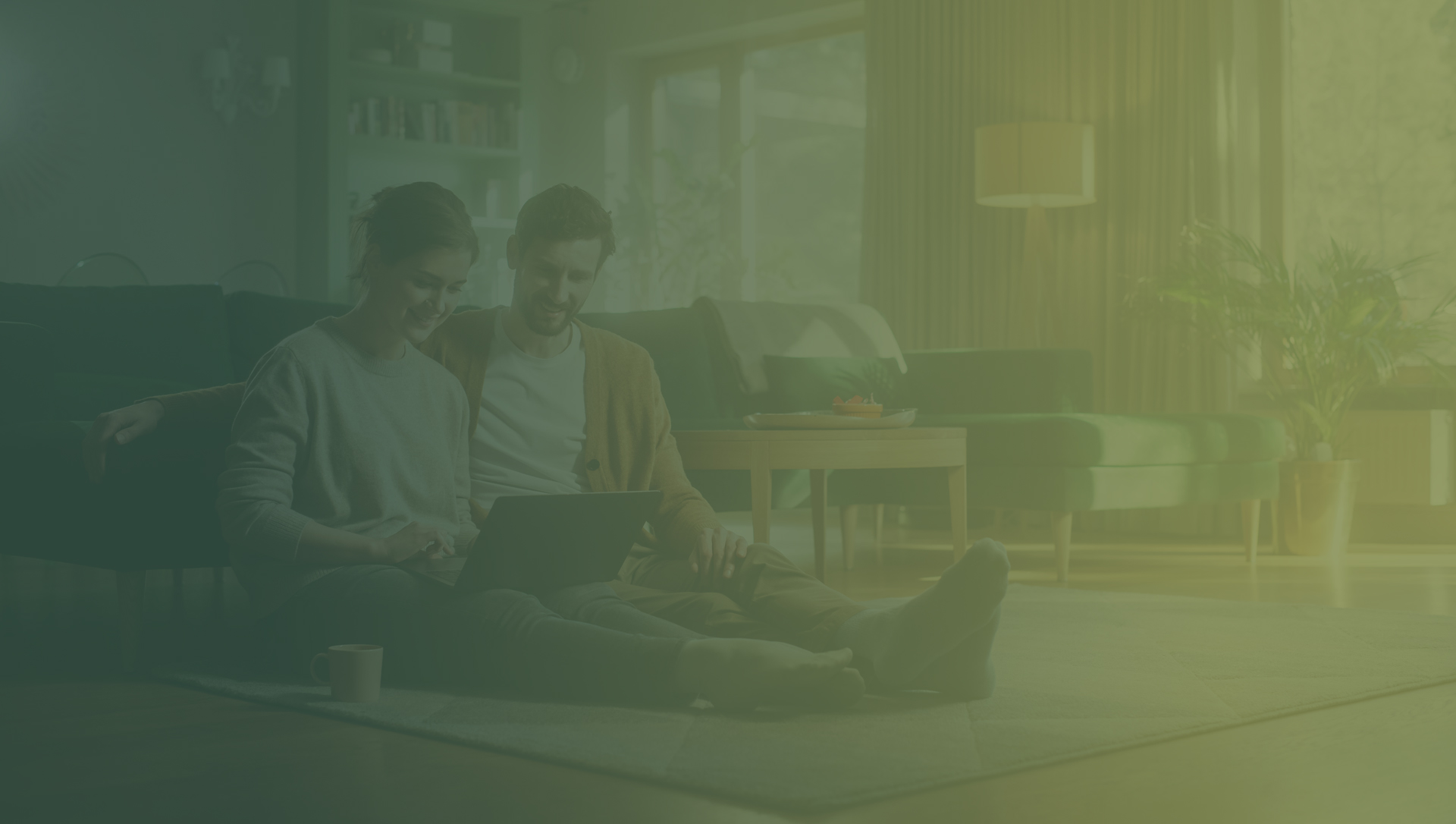 Couple sitting on the living room floor using a laptop together